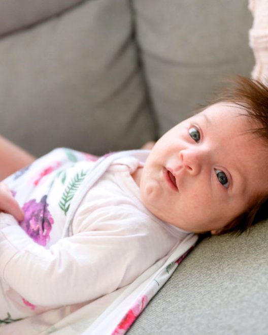 Baby lying on sofa with bright eyes
